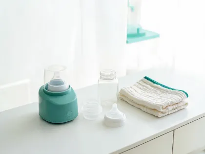 Newborn feeding setup with bottle warmer and clean bottle parts