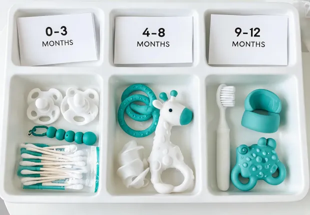 Pacifiers and teethers sorted by age stage in a clean care tray