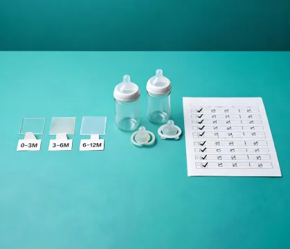 Organized baby feeding safety documents with bottles and silicone parts
